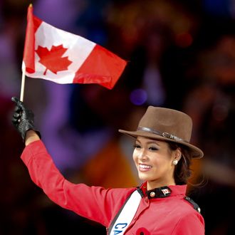 Kesiah Papasin of Canada waves a Canadian national flag as she poses in a costume during the 54th Miss International Beauty Pageant in Tokyo