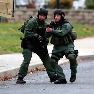 Police move near the scene of a shooting Monday, Dec. 15, 2014, in Souderton, Pa. Police are surrounding a home in Souderton, outside Philadelphia, where a suspect is believed to have barricaded himself after shootings at multiple homes. Police tell WPVI-TV the man is suspected of killing a five people Monday morning at three different homes northwest of Philadelphia. 