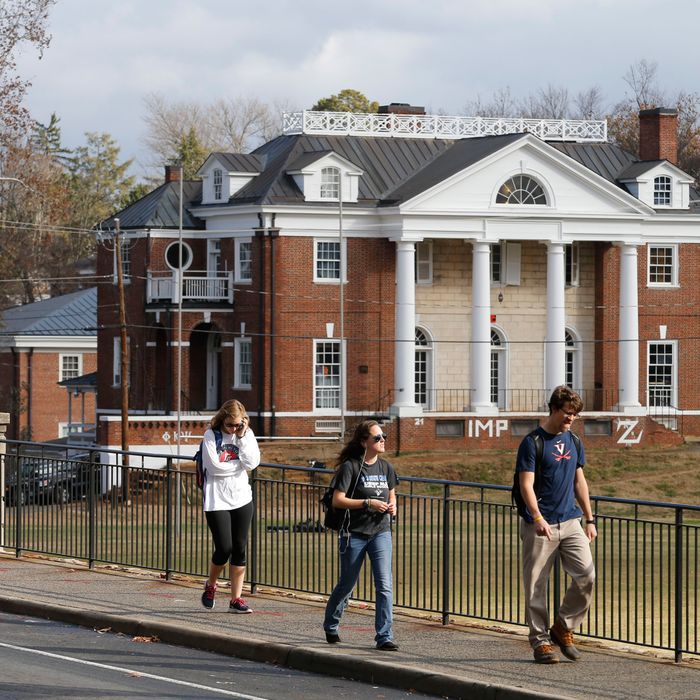 FILE - In this Monday, Nov. 24, 2014, file photo, University of Virginia students walk to campus past the Phi Kappa Psi fraternity house at the University of Virginia in Charlottesville, Va. Rolling Stone is casting doubt on the account it published of a young woman who says she was gang-raped at a Phi Kappa Psi fraternity party at the school, saying there now appear to be discrepancies in the student's account. (AP Photo/Steve Helber, File)