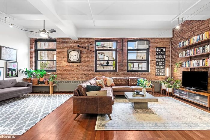 A listing photo showing the living area of a loft studio apartment in Park Slope.