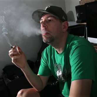 In this March 10, 2016, photo, former U.S. Marine, Mike Whiter smokes marijuana before he starts editing a video project at his home in Philadelphia.