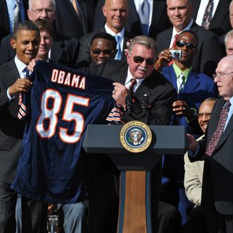 Head coach Mike Ditka (C) presents a jersey to US President Barack Obama as defensive co-ordinator Buddy Ryan (R) looks on during an event celebrating 1985 Super Bowl champions, the Chicago Bears, October 7, 2011 on the South Lawn of the White House