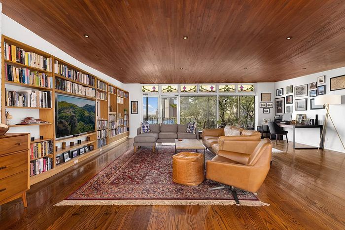 It's hard to tell in this listing photo, but the living room ceiling has a slight curve, like a ship's hull. The bookshelves are original Mailer ones.