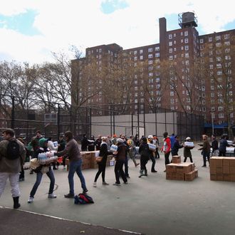 NEW YORK, NY - NOVEMBER 03: Personel from New York Mayor Michael Bloomberg's office deliver food to the Red Hook public housing project on November 3, 2012 in the Brooklyn borough of New York City. The low-income apartment complex remains without power or water 5 days after Superstorm Sandy. (Photo by John Moore/Getty Images)