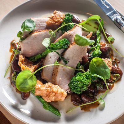 Heritage milk-fed pig: slow-roasted leg with bean ragout and broccoli rabe.