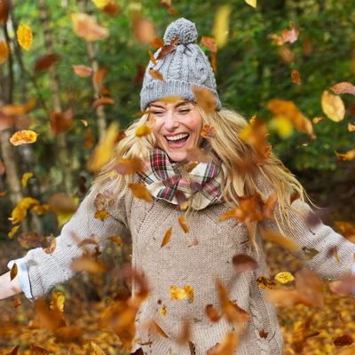 Woman playing in the leaves.