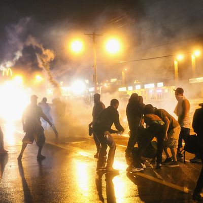 FERGUSON, MO - AUGUST 17: Police fire tear gas at demonstrators protesting the shooting of Michael Brown after they refused to honor the midnight curfew on August 17, 2014 in Ferguson, Missouri. The curfew was imposed on Saturday in an attempt to reign in the violence that has erupted nearly every night in the suburban St. Louis town since the shooting death of teenager Michael Brown by a Ferguson police officer on August 9. (Photo by Scott Olson/Getty Images)