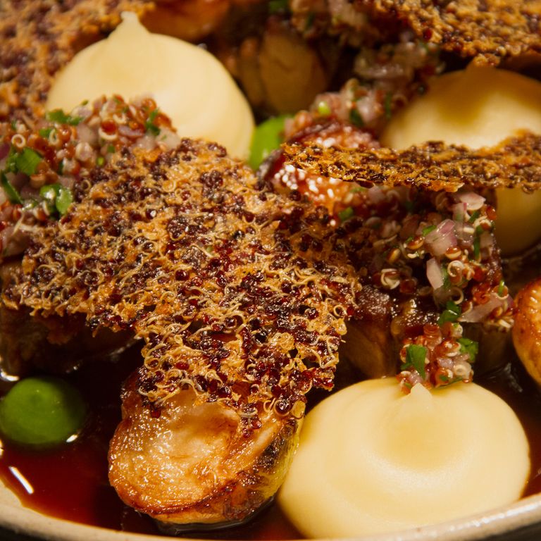 Tender hunks of braised goat neck are crowned with quinoa crisps.