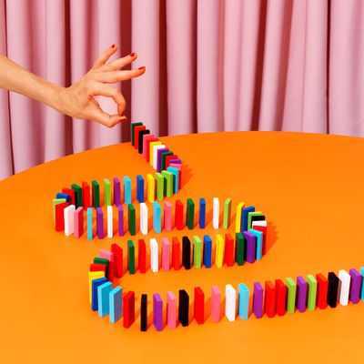 Anonymous Hands Perform A Domino Trick