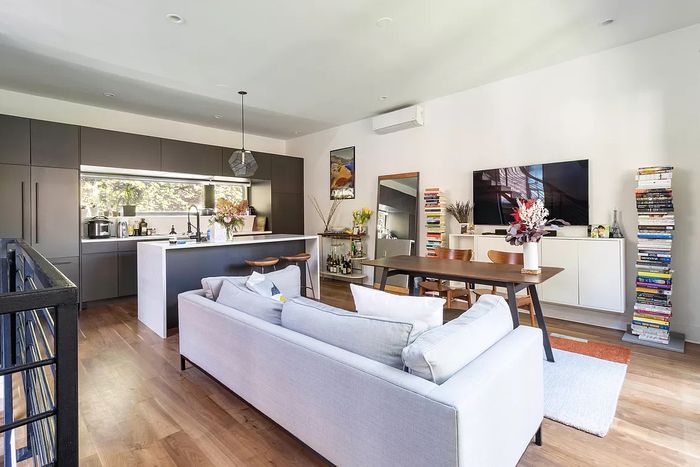 Living room with a charcoal-colored kitchen.