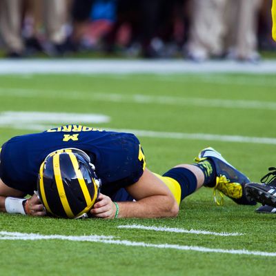 In this Sept. 27, 2014, photo, Michigan quarterback Shane Morris lays on the field after taking a hit in the fourth quarter of an NCAA college football game against Michigan in Ann Arbor, Mich. Early Tuesday, Sept. 30, 2014, roughly 12 hours after embattled Michigan coach Brady Hoke said he'd been given no indication that Morris had been diagnosed with a concussion, athletic director Dave Brandon revealed in a post-midnight statement that the sophomore did appear to have sustained one.