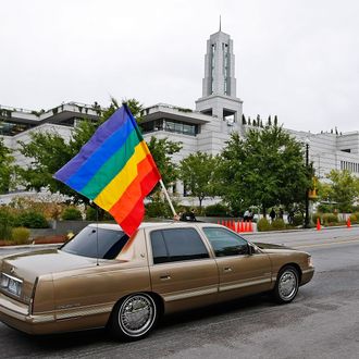  A car flies the gay pride flag in protest past the Mormon Conference center during the Semi-Annual General Conference of the Mormon church