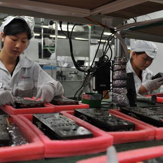 Workers inspect motherboards on a factory line at the Foxconn plant in Shenzen on May 26, 2010. The Taiwanese boss of Apple manufacturer Foxconn headed to a sprawling factory in southern China where a spate of worker suicides have stoked anger about labour conditions. Terry Gou, the chairman of Foxconn's parent company Hon Hai Precision, flew into the booming city of Shenzhen aboard his private jet with travelling Taiwanese reporters, urging the media to see the factory for themselves. AFP PHOTO / VOISHMEL (Photo credit should read VOISHMEL/AFP/Getty Images)