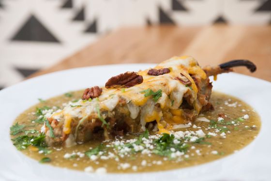 Javelina&#8217;s Chile Relleno - poblano pepper, battered and fried, filled with beef piccadillo, topped with melted cheese, toasted pecans, raisins, and tomatillo sauce.