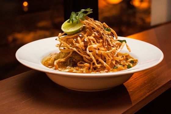 Kao Soy: soft and fried egg noodles in Chiang Mai curried soup with dark-meat chicken, pickles, papaya fritters, shallots, and chile oil.