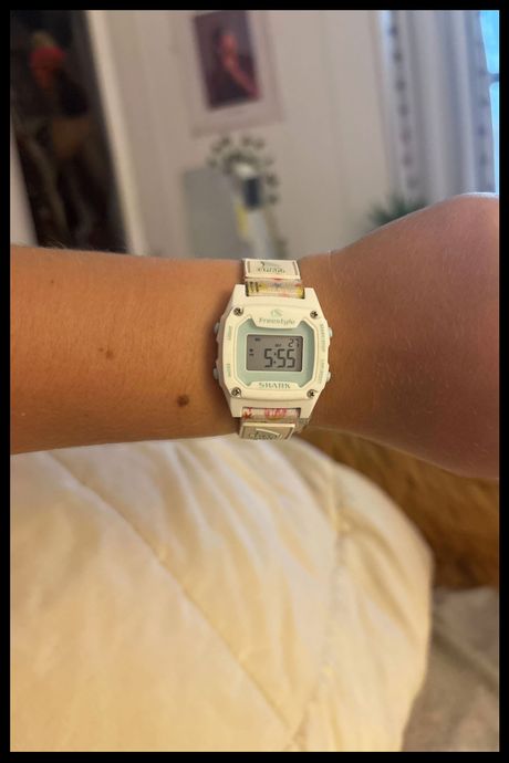 Photo of a digital Shark Watch on the wrist of high school senior Charlotte's wrist. 