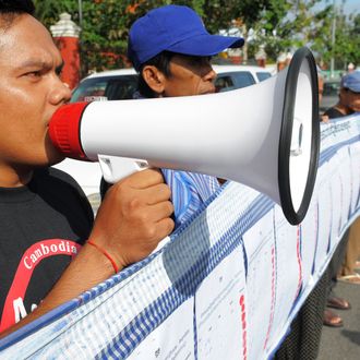 A Cambodian man shouts slogans as people hold a 230-meters long petition during a protest in front of the National Assembly building in Phnom Penh on December 20, 2011. Cambodian people and rights activists filed a petition at the National Assembly to request the body not to adopt a controversial draft of the law on Associations and NGOs. They said the law is being created with an intention to control rather than to promote and strengthen civil society, and as such it undermines the rights of the people and shrinks democratic space in Cambodia.