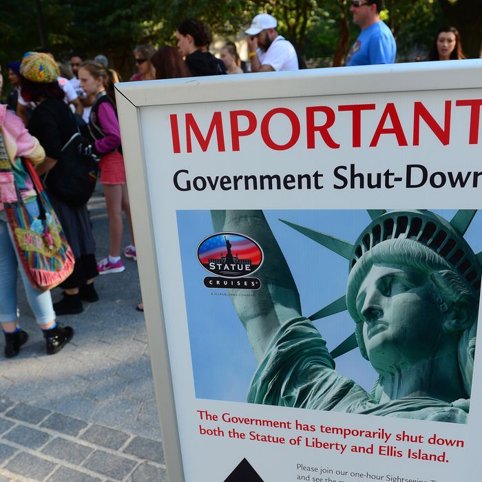 Tourists walk by a sign announcing that the Statue of Liberty is closed due to a US government shutdown in New York, October 1, 2013. Government institutions and national parks around the US were closed and thousands of employees were furloughed after Congress was unable to agree on a federal budget and shut down the goverment for the first time in 17 years. 