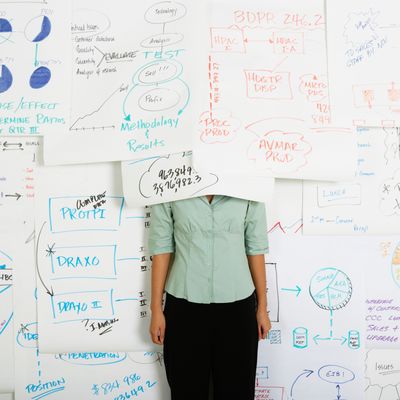 Businesswoman standing with head under flow chart