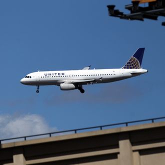 NEW YORK, NY - APRIL 05: A United Airlines airplane flies along it's landing path towards LaGuardia International Airport as the New York Mets host the Atlanta Braves during their Opening Day Game at Citi Field on April 5, 2012 in New York City. (Photo by Nick Laham/Getty Images)