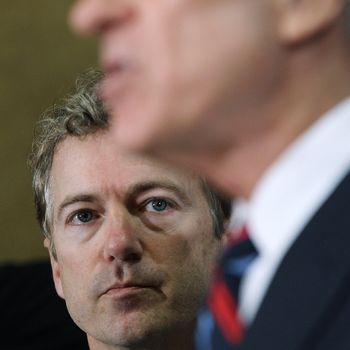 DES MOINES, IA - JANUARY 02: U.S. Sen. Rand Paul (R-KY) (L) looks on as his father, Republican presidential hopeful U.S. Rep Ron Paul (R-TX) speaks during a campaign stop at the Downtown Des Moines Marriott Hotel on January 2, 2012 in Des Moines, Iowa. With one day to go before the Iowa caucuses, Ron Paul makes a final campaign push with a whistle-stop tour through Iowa. (Photo by Justin Sullivan/Getty Images)