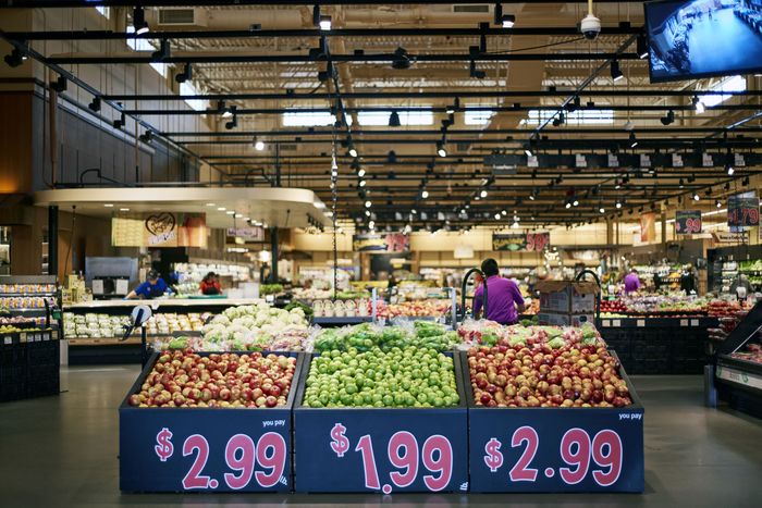 A grocery display with three kinds of apples in the produce section of Wegmans supermarket