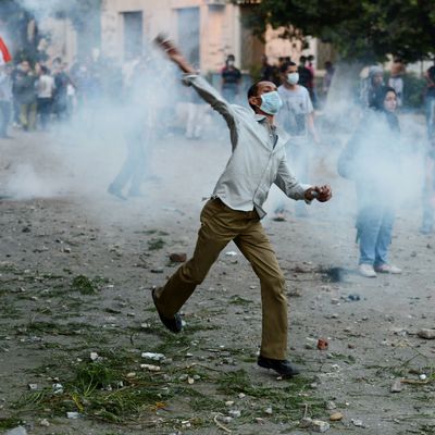 Egyptian protesters throw stones towards riot police during clashes near the US embassy in Cairo on September 13, 2012. Police used tear gas as they clashed with a crowd protesting outside the US embassy in Cairo against a film mocking Islam.