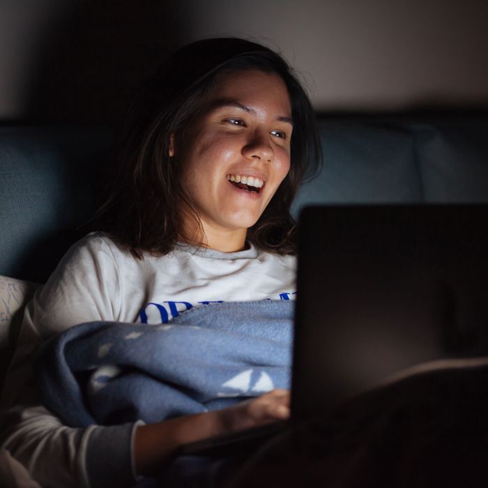 Woman on laptop at night.