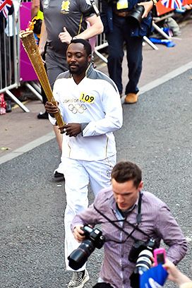 The Best Part of This Picture Is… imagining your own fan-fiction romance between the male and female Olympic security guards running alongside will.i.am.
Is This Person Worthy to Carry the Torch? Why exactly is will.i.am there? Because he knows Cheryl Cole? Because he judges the U.K. version of The Voice? apl.de.ap went to Buckingham Palace once … where's HIS torch?