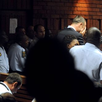 South Africa's Olympic sprinter Oscar Pistorius (2nd R) buries his face in his hands in the court room during his hearing on charge of murdering his model girlfriend Reeva Steenkamp on Valentine's Day on February 15, 2013 at the Magistrate Court in Pretoria. South African prosecutors will argue that Pistorius is guilty of premeditated murder in Steenkamp's death, a charge which could carry a life sentence.