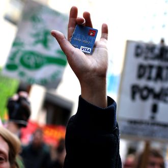 An Occupy Wall Street protestor holds up a cut up credit card during a demonstration on September 17, 2012 in San Francisco, California. An estimated 100 Occupy Wall Street protestors staged a demonstration and march through downtown San Francisco to mark the one year anniversary of the birth of the Occupy movement.