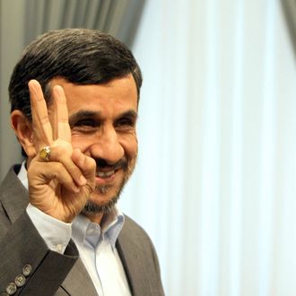 Iranian President Mahmoud Ahmadinejad flashes the V-sign for victory as he waits for the arrivak of Qatari Minister of State for International Cooperation Khaled bin Mohammed al-Attiyah in Tehran on October 13, 2011. 