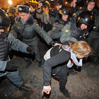 Riot police detain a Russian opposition activist taking part in an unauthorized rally, on Triumfalnaya Square in central Moscow, late on December 6, 2011. Opposition leaders defied the Russian authorities today by organizing a second mass protest in two days against Vladimir Putin's 12-year rule, despite warnings of a police crackdown and the jailing of one of the organizers.