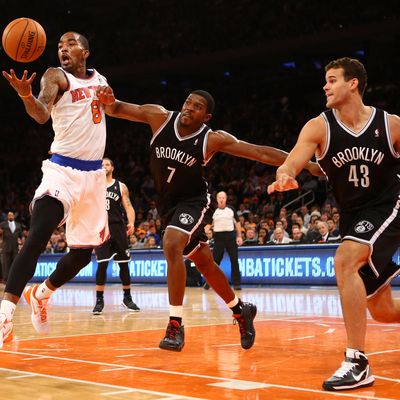 J.R. Smith #8 of the New York Knicks grabs a rebound as Joe Johnson #7, and Gerald Wallace #45 of the Brooklyn Nets defend during their game at Madison Square Garden on December 19, 2012 in New York City. 