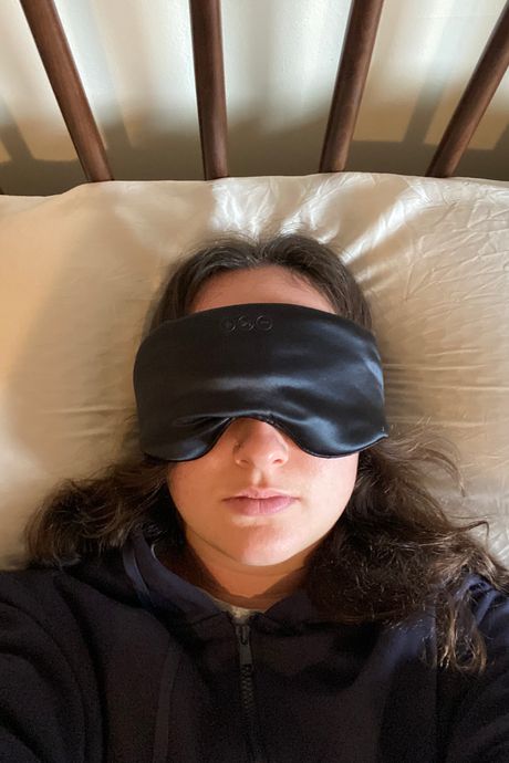 A person wearing a black silk eye mask.