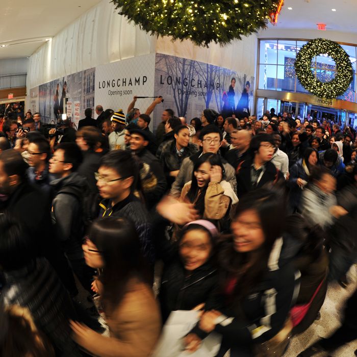 People rush into Macy's department store as they open at midnight (0500 GMT) on November 23, 2012 in New York to start the stores' 