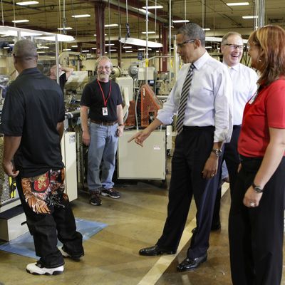US President Barack Obama (R) points to a worker's jeans as tours the Honeywell Golden Valley facility in Minneapolis, Minnesota on June 1, 2012. 
