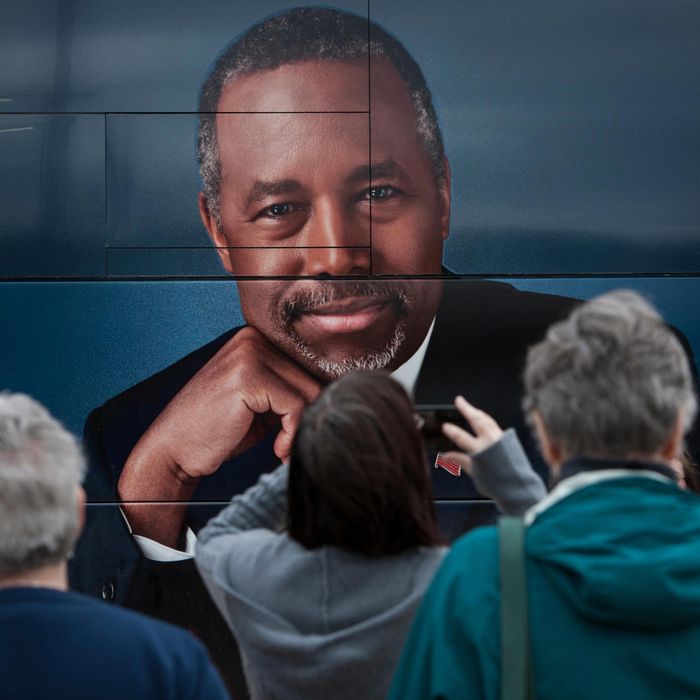 Supporters of Dr. Ben Carson stand near his book tour bus in Ames, Iowa