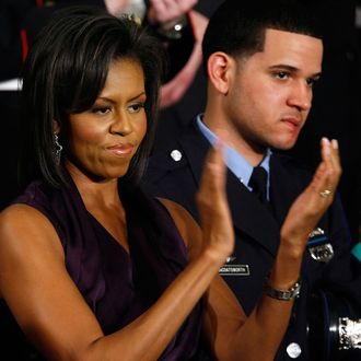 U.S. First Lady Michelle Obama applauds her husband, U.S. President Barack Obama, while he addresses a joint meeting of Congress as Philadelphia Police Officer Richard DeCoatsworth (R) stands by her February 24, 2009 at the U.S. Capitol in Washington, DC. In his remarks Obama was expected to address the topics of the struggling U.S. economy, the budget deficit, and health care. 