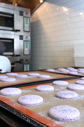 与此同时，糕点部制作了无数盘教科书式的马卡龙。这些是紫罗兰味的，准备参加今晚在餐厅屋顶的一个私人派对。它们将作为临别礼物包装，包括两块酥饼板和两片pâte de水果。