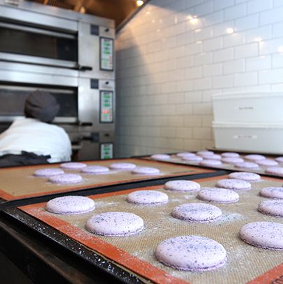 与此同时，糕点部制作了无数盘教科书式的马卡龙。这些是紫罗兰味的，准备参加今晚在餐厅屋顶的一个私人派对。它们将作为临别礼物包装，包括两块酥饼板和两片pâte de水果。