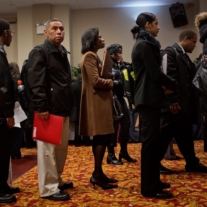 Job seekers wait to talk to recruiters and fill out applications at a job fair in New York, U.S., on Thursday, Jan. 16, 2014. 