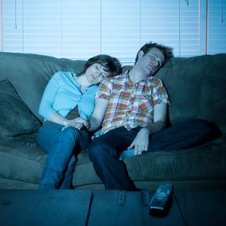 Young couple fallen asleep in front of tv