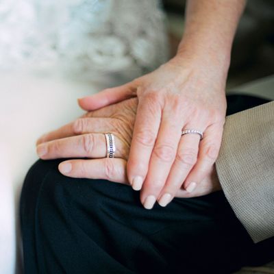 An elderly couple with wedding bands.