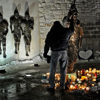 STATE COLLEGE, PA - JANUARY 22: A member of the community pays respect to the statue of Joe Paterno, the former Penn State football coach, outside of Beaver Stadium in the early hours of January 22, 2012 in State College, Pennsylvania. The community was reacting to news that Joe Paterno, who is suffering from lung cancer and who was fired in November in the aftermath of child sex abuse charges against a former assistant, was in serious condition. (Photo by Patrick Smith/Getty Images)
