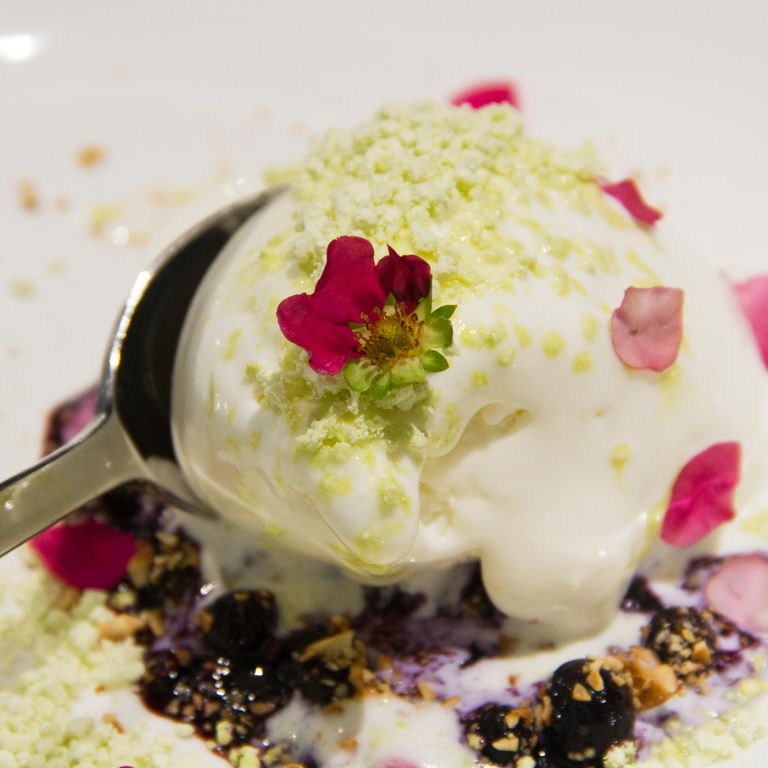 玫瑰天竺葵冰淇淋配烤蓝莓果盘和腰果。