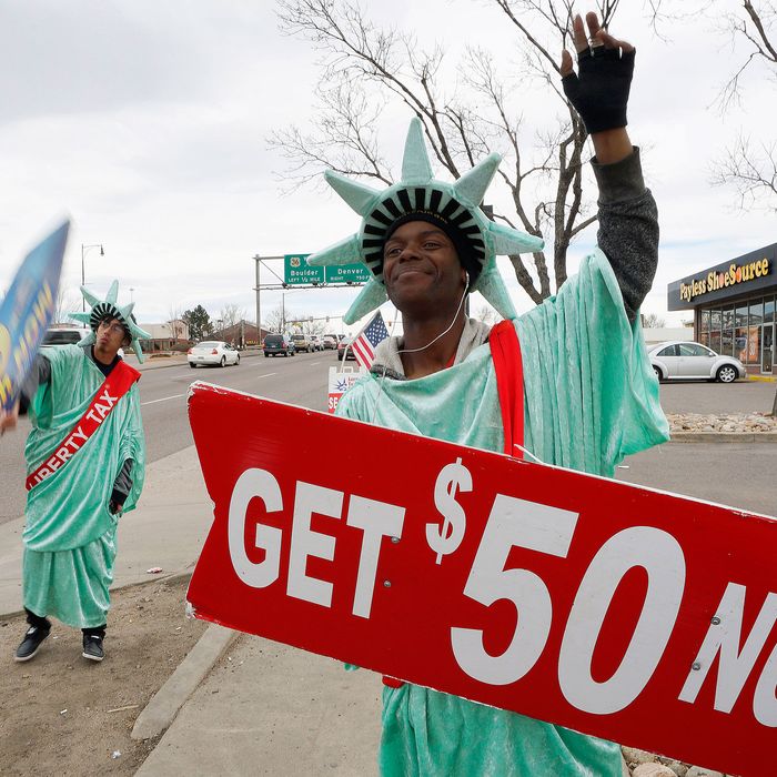 Manuel Martinez (R) and Jose, both dressed like the Statue of Liberty, wave signs advertising the Liberty Tax preparation business in Denver February 14, 2015. Tax season is in full swing in the U.S. with federal tax returns due to be filed April 15th. REUTERS/Rick Wilking (UNITED STATES - Tags: SOCIETY BUSINESS) --- Image by ? RICK WILKING/Reuters/Corbis