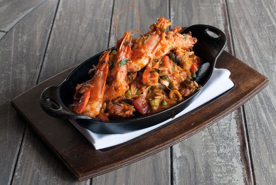 Spicy Greek paella with merguez, mussel, clam, prawn, scallop, and orzo.