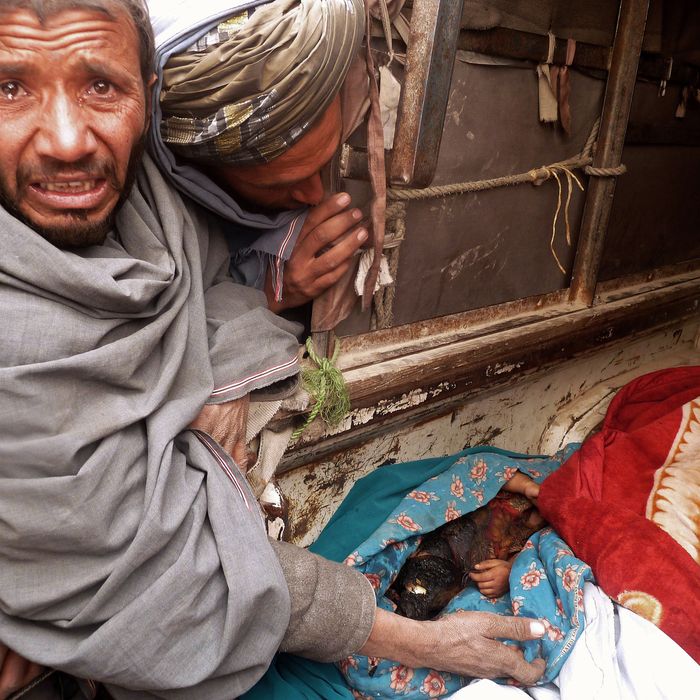 A mourner cries over the bodies of Afghan civilians, allegedly shot by a rogue US soldier, seen loaded into the back of a truck in Alkozai village of Panjwayi district, Kandahar province on March 11, 2012. An AFP reporter counted 16 bodies -- including women and children -- in three Afghan houses after a rogue US soldier walked out of his base and began shooting civilians early Sunday. NATO's International Security Assistance Force said it had arrested a soldier