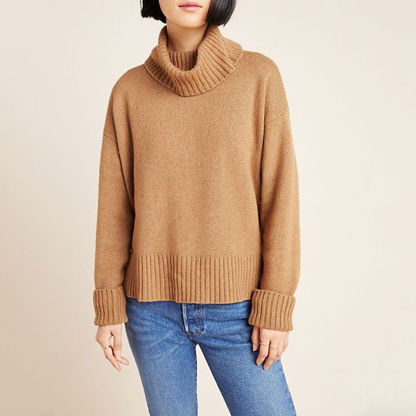 A relaxed, loose fitting tan Blair Turtleneck Sweater with a relaxed collar and rubbed scuffs, neck, and waist and a pair of distressed jeans on a model. The Strategist - 48 Things on Sale You’ll Actually Want to Buy: From Sunday Riley to Patagonia